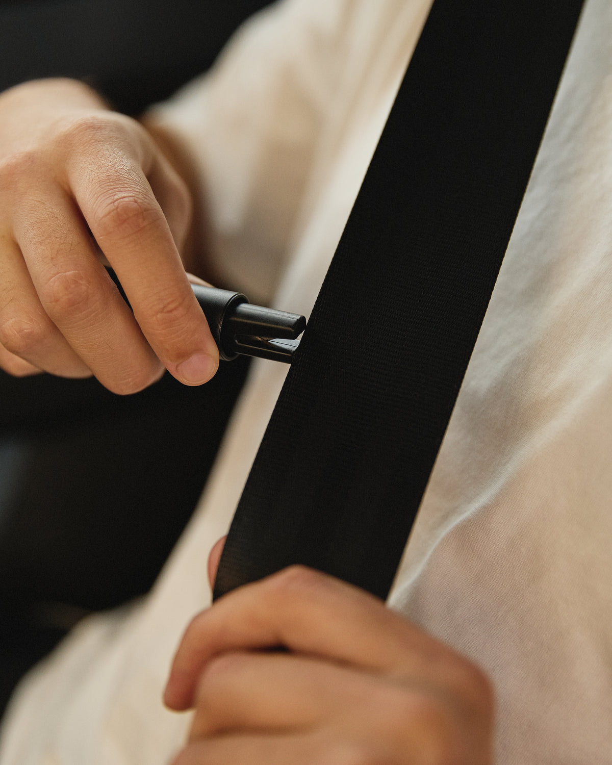 Enclosed blade cutting a seatbelt